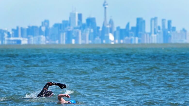 People swim in the frigid waters of Lake Ontario overlooking The City of Torontos skyline in Mississauga.