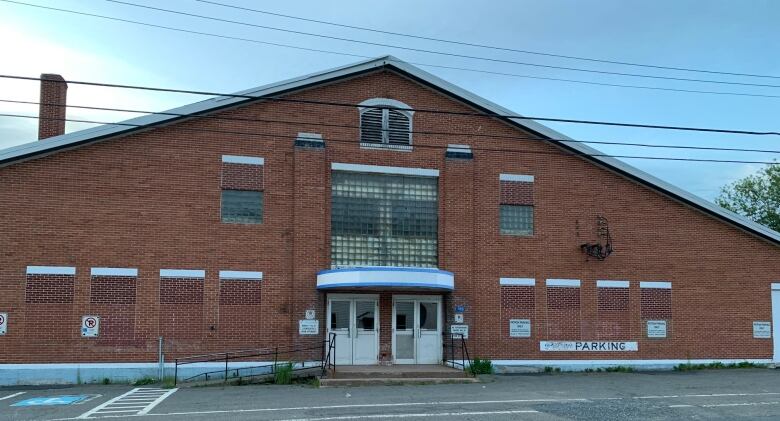 A triangular brick building behind a parking lot.