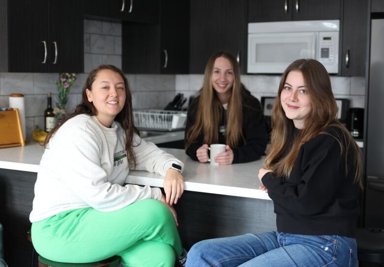 Jess Walsh (right) is pictured with two of her roommates in her kitchen in Banff.