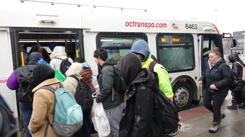 People line up to board a city bus.