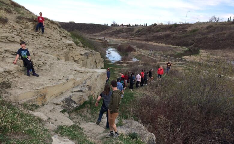 People walk in a line through the park.