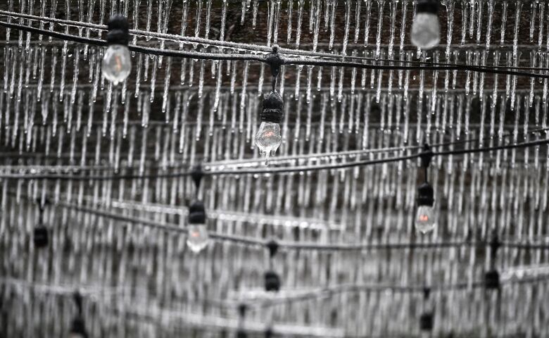 Icicles hanging from a ceiling and string lights.