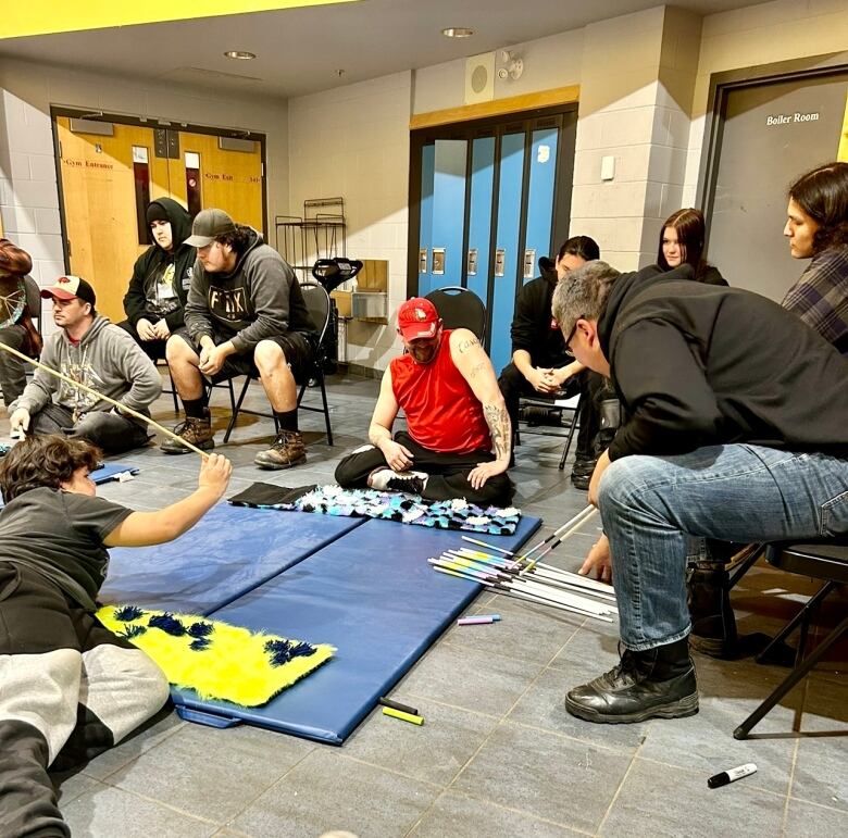 Multiple people gathered in a room take part in activities as part of a recovery program 