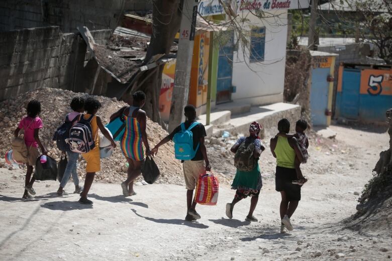 People flee their homes to avoid clashes between armed gangs in the Diegue district of Petion-Ville, Haiti on March 23, 2023.