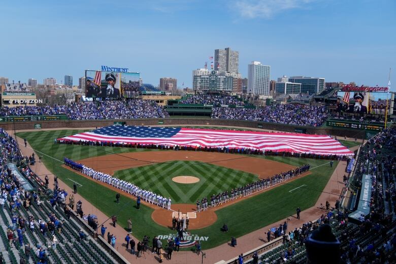 A large American flag is unfurled in the outfield at Wrigley Field in Chicago.