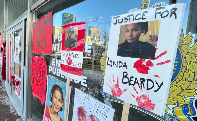 Signs that read 'justice for Linda Beardy' were posted on the windows of a police headquarters during a rally.