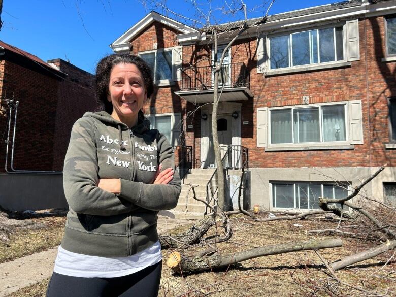 A woman stands in front of a house.