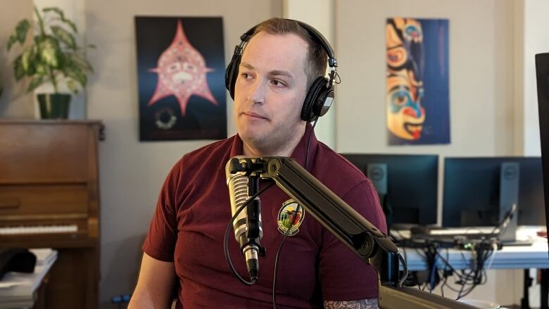 A man wearing headphones talks during an interview in a radio studio.