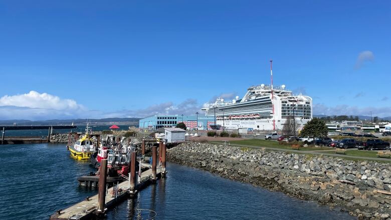 A cruise ship sits at a dock on a sunny day.