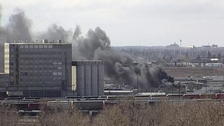 A black smoke cloud is pictured in the distance.