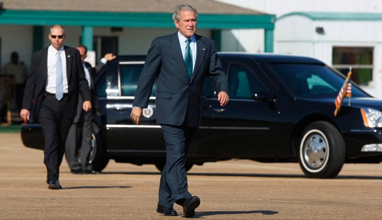 Then president George W. Bush is followed by Secret Service agents and his limousine as he walks back to Air Force One in 2008. 