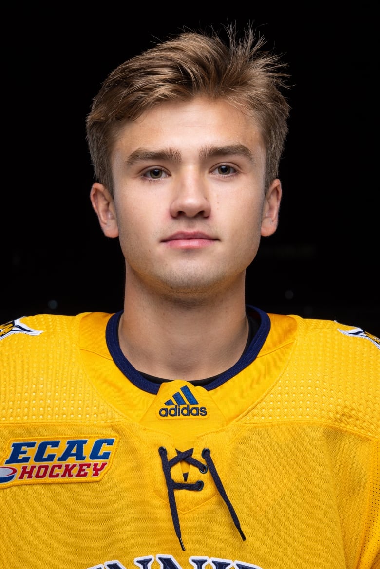 A young hockey player poses for a headshot.