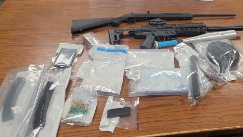 Evidence from traffic stop, including two long guns, laid out on table.