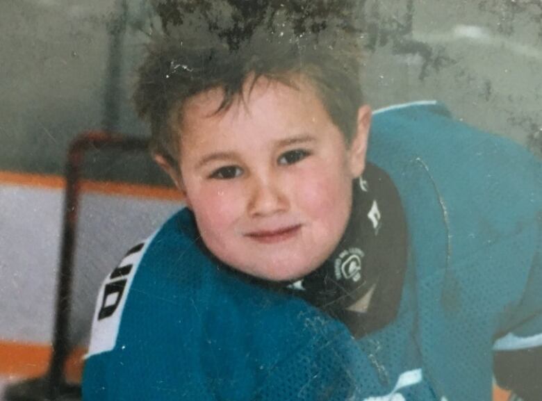 A boy smiling in an old photo.