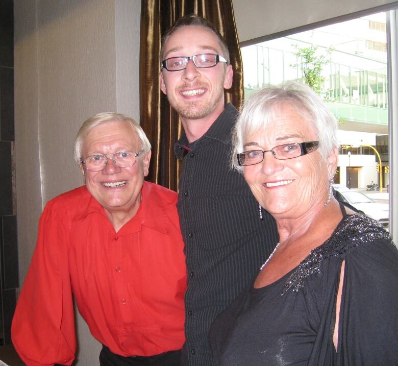 3 people stand facing the camera and smiling