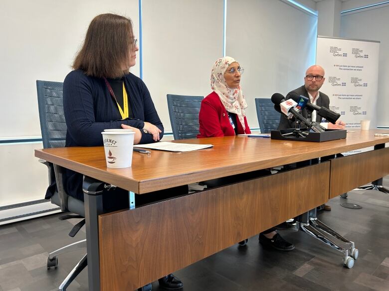 Three people are sitting at a table.