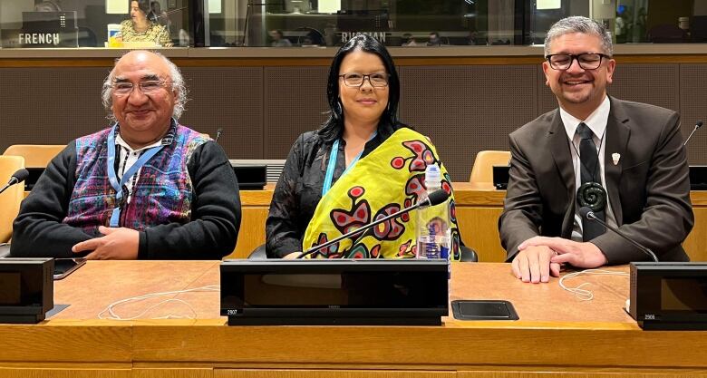 Two men and a woman seated at the UN.