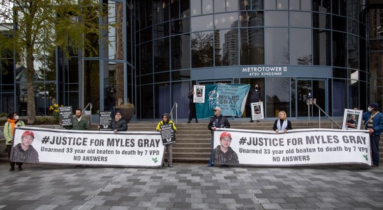 People with black and white banners reading 