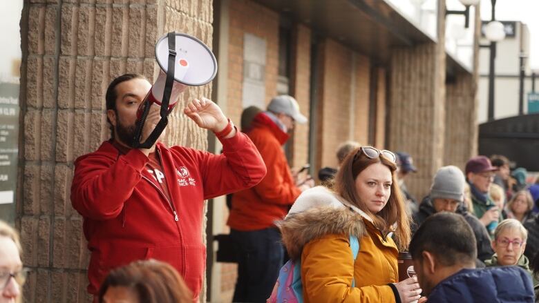 A union representative speaks into a bullhorn at a rally.