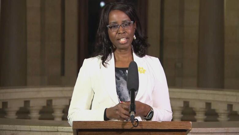 A woman is pictured speaking into a podium.