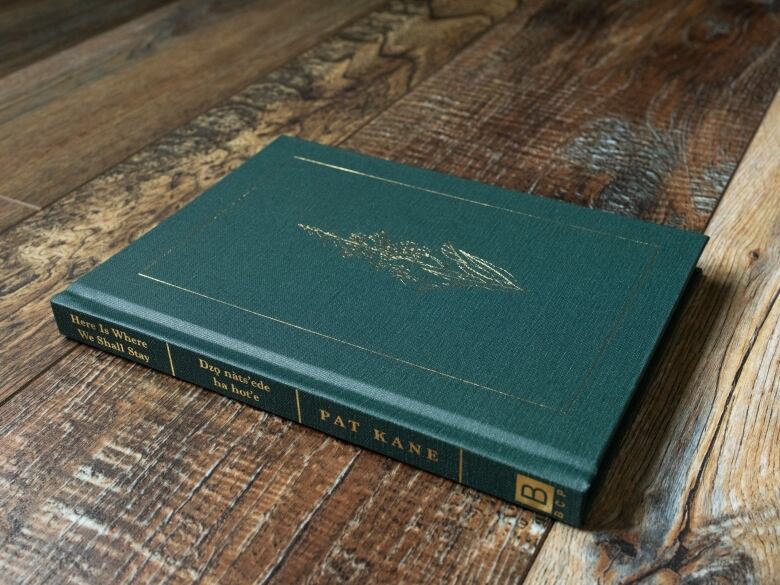 Green book on wood table.