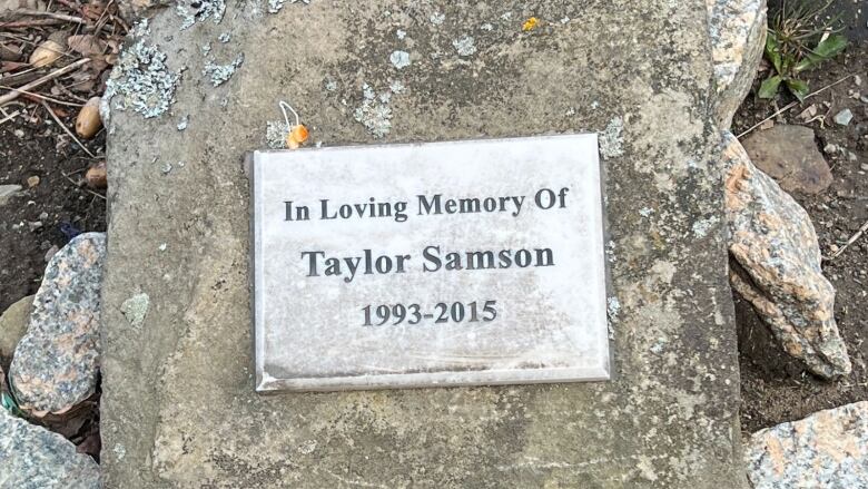 a silver plaque on a rock.