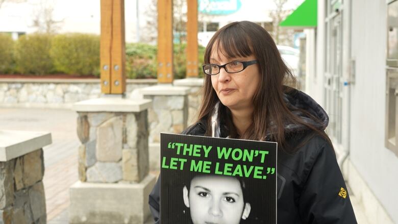 Cyndy Hall holds up a sign with Lisa Marie Young's final words on it. 