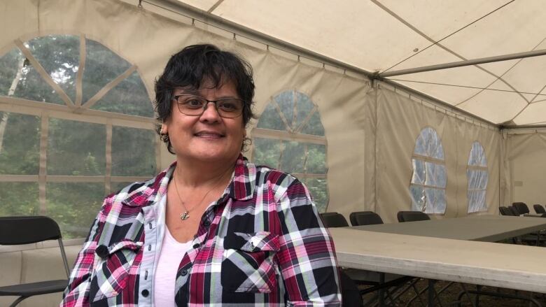 Woman with glasses smiling at the camera.