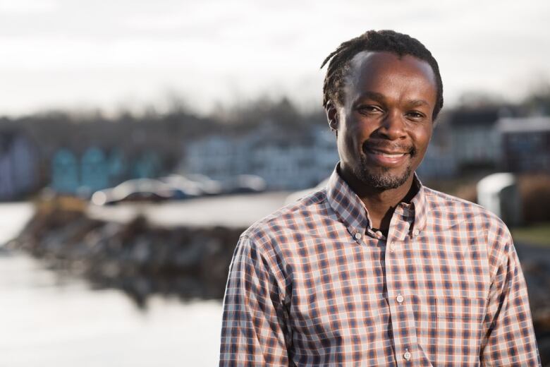 A man stands in front of the waterfront.