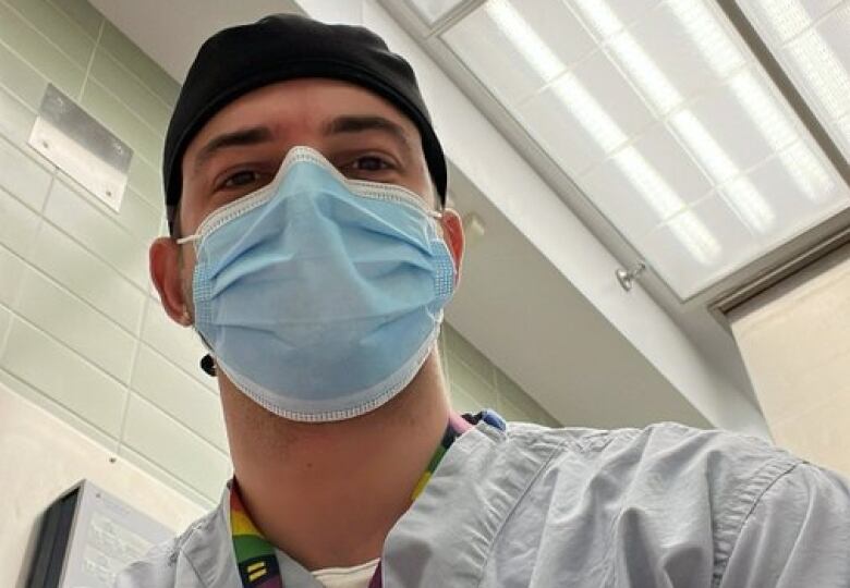 Dr. Jonathan Cluett looks into the camera wearing blue scrubs and a surgical cap.