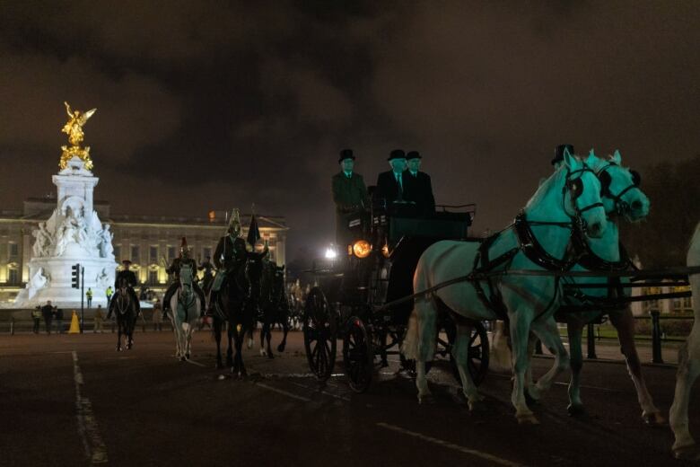 White horses pull a carriage in front of a palace.