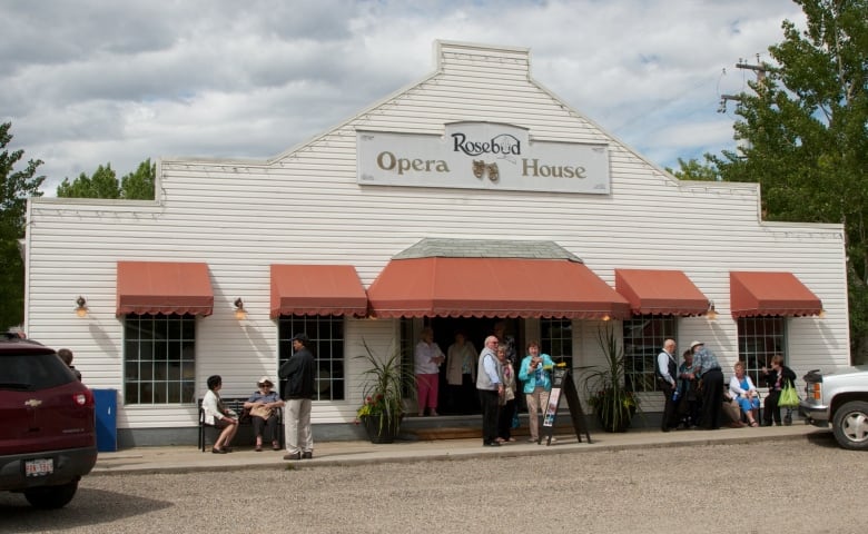 People stand outside a theatre.