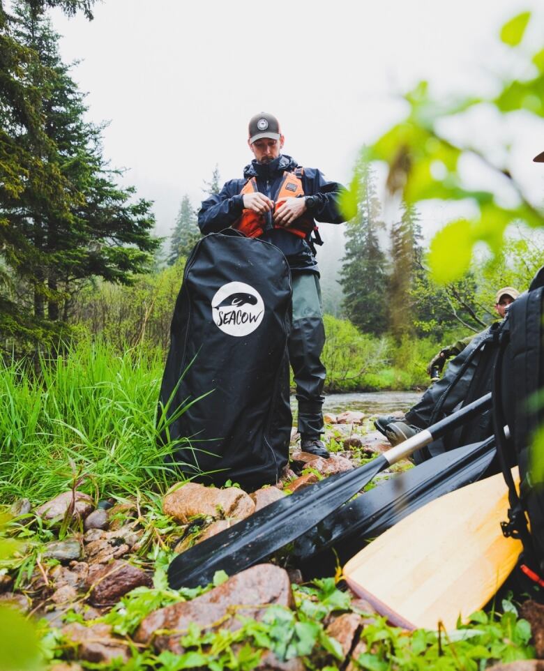 Lee Fraser of Live Life in Tents zipping up a life jacket outside.