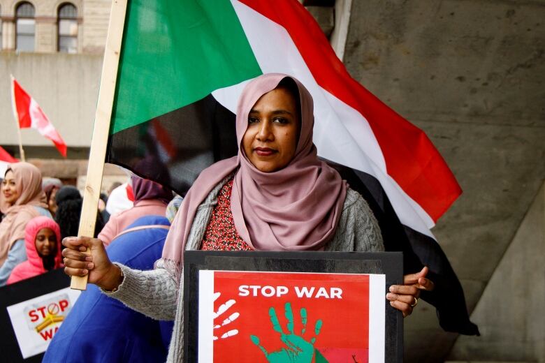 Randa Mohamed holds a stop war sign at a rally to oppose fighting in Sudan at Nathan Phillips Square in Toronto on April 23, 2023.