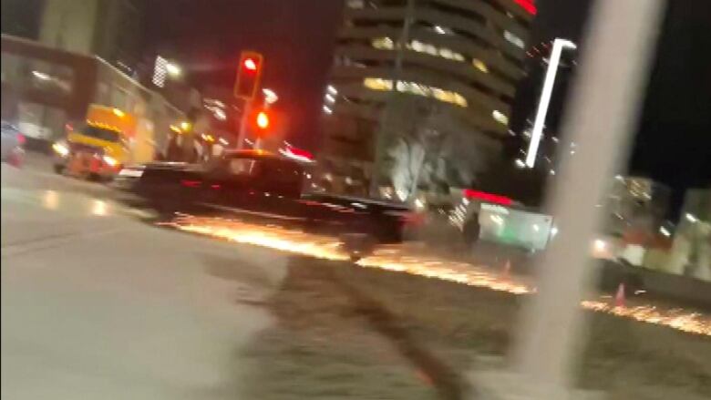 A blurry truck is seen shooting sparks off the pavement.