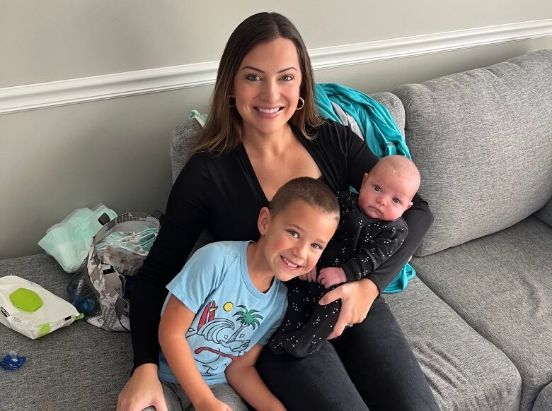 Woman sits with boy and baby