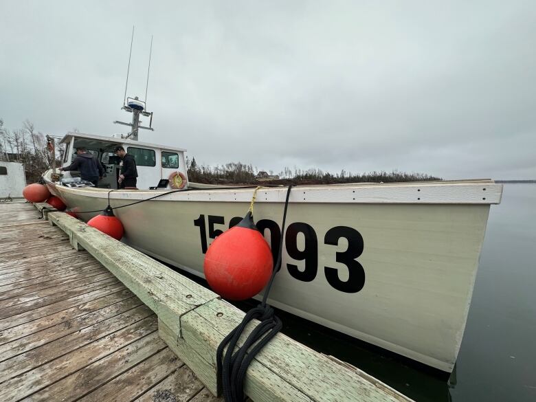 A lobster boat tied up at a wharf 