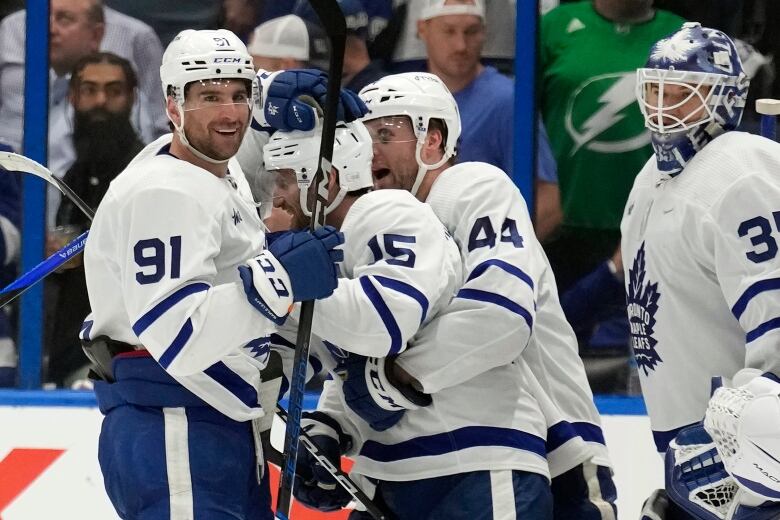 A group of men's hockey players celebrate after a win.