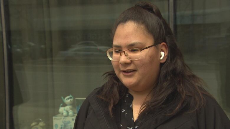 A woman is wearing glasses and a black shirt. 