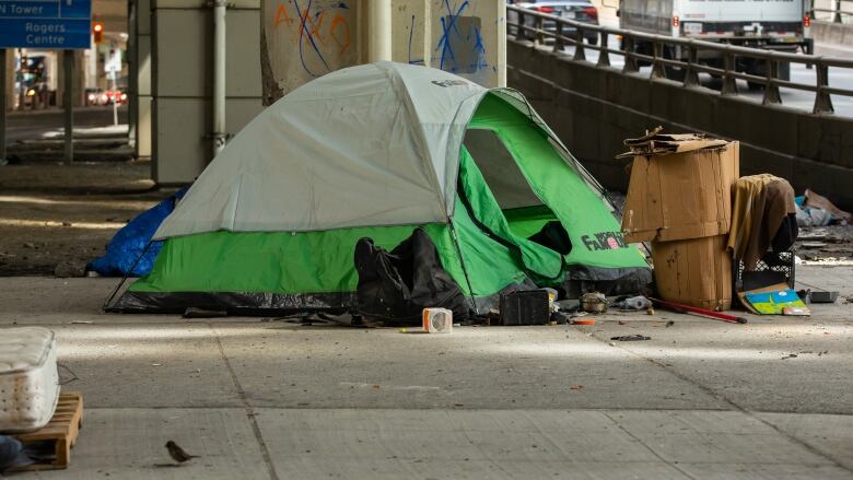 A tent under the Gardiner Expressway at Lake Shore Boulevard West and York Street on March 24, 2023.. See tent, fly and belongings under the road beside the on-ramp. Recent city data shows Toronto saw an average of more than three deaths per week among people experiencing homelessness last year, totaling 187 deaths in 2022.