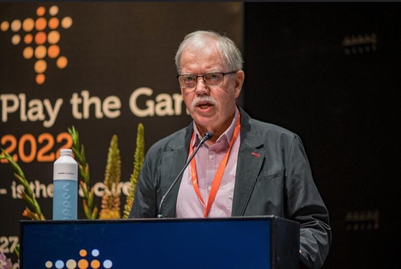 A man speaks at a podium during a conference.