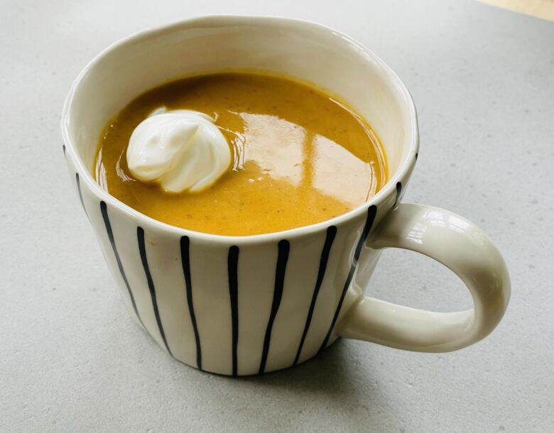 A cup of soup in a mug.