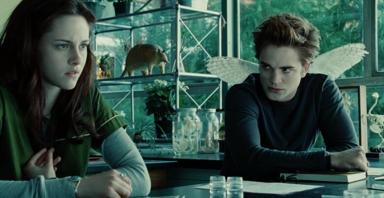 Still frame from the first Twilight movie. Kristen Stewart looking confused and Robert Pattinson scowling in a science classroom.