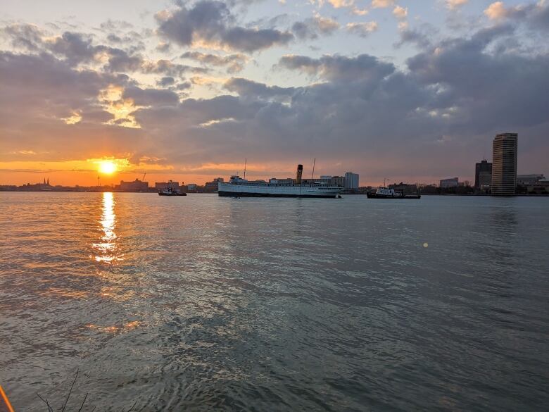 A ship in the Detroit river at sunset. 