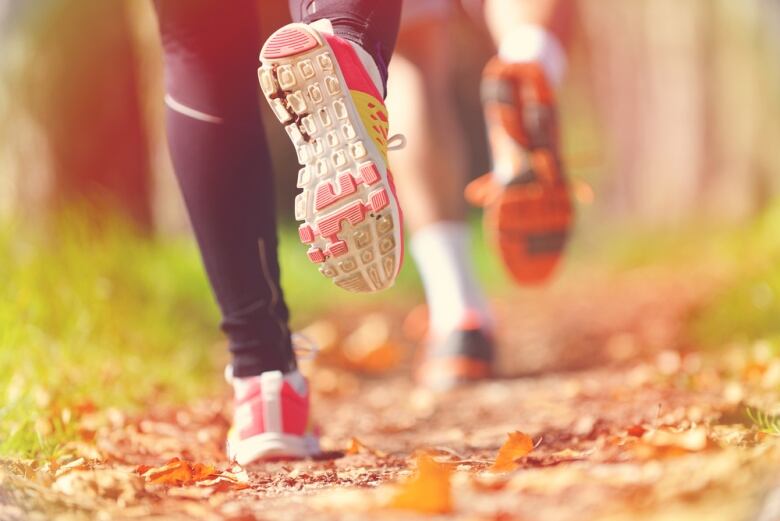 view of two people running, close up on running shoes. 