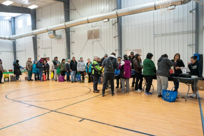 Community members from Whitesand First Nation stand in a long line to pay for their items