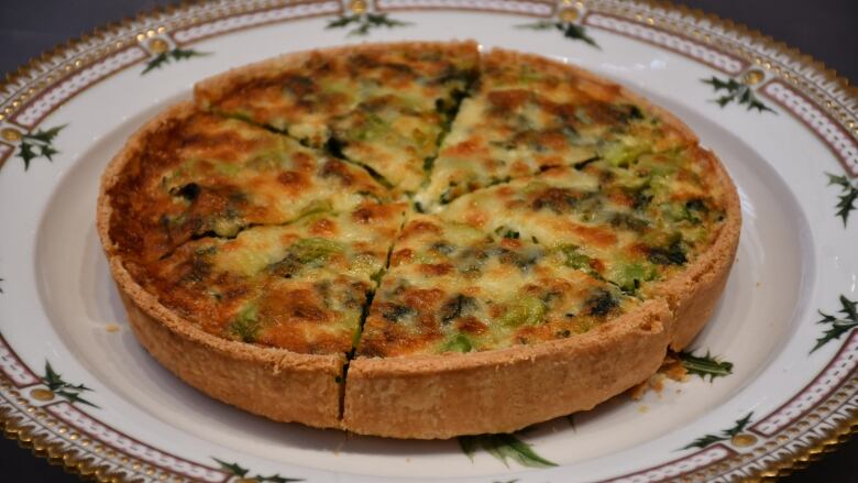 A 'coronation quiche' sits on a fine china plate.