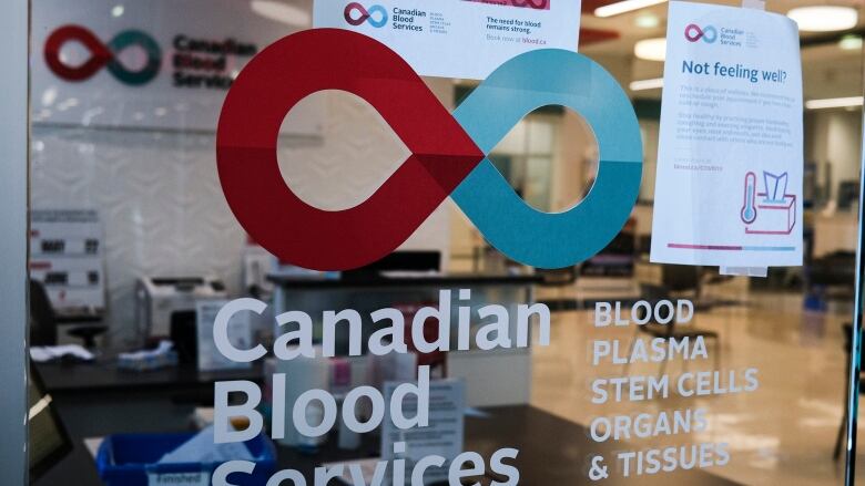 A blood donor clinic pictured at a shopping mall in Calgary. The window is printed with  'Canadian Blood Services' and a red and blue logo.