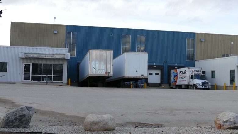 A view of several trucks parked outside a business in an industrial lot.