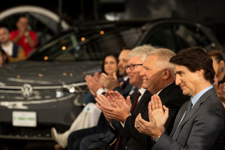 Prime Minister Justin Trudeau and Ontario Premier Doug Ford applaud during an announcement on a Volkswagen electric vehicle battery plant at the Elgin County Railway Museum in St. Thomas, Ont. on April 21, 2023.